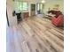 Open-concept living area with wood-look flooring and comfortable seating arrangement at 625 Duchess Blvd, Dunedin, FL 34698
