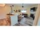 Open-concept living room featuring wood floors, fireplace, and kitchen pass-through at 625 Duchess Blvd, Dunedin, FL 34698