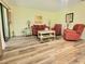 Spacious living area with wood-look floors, comfortable furniture, and sliding glass doors at 625 Duchess Blvd, Dunedin, FL 34698