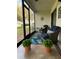 Relaxing screened patio showcasing comfortable chairs, a vibrant rug, and outdoor ambiance at 625 Duchess Blvd, Dunedin, FL 34698