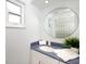 Bright bathroom featuring a round mirror, a white sink, and minimalist design at 721 Cadiz Rd, Venice, FL 34285