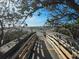 Beach access with wooden walkway leading to sandy beach and ocean views through lush, mature trees at 721 Cadiz Rd, Venice, FL 34285