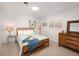 Cozy bedroom featuring a bed with blue throw and light blue quilt, white walls and tile floors at 721 Cadiz Rd, Venice, FL 34285