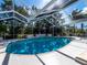 Inviting screened-in pool area with palm trees and lush tropical landscaping at 721 Cadiz Rd, Venice, FL 34285