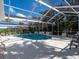 Screened-in pool area featuring a spacious deck, lounge chairs, and lush landscaping at 721 Cadiz Rd, Venice, FL 34285