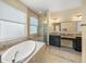Luxurious bathroom with a soaking tub, glass-enclosed shower, and dual vanity sinks at 7911 Kavanagh Ct, Sarasota, FL 34240