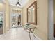 Elegant foyer features tile flooring, transom window over double doors, and decorative mirror at 7911 Kavanagh Ct, Sarasota, FL 34240