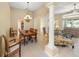 Open-concept living and dining area with columns, chandelier, and large windows offering natural light at 7911 Kavanagh Ct, Sarasota, FL 34240