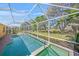 A screened-in pool and spa is surrounded by tropical plants and mature trees at 7911 Kavanagh Ct, Sarasota, FL 34240