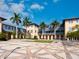 Exterior courtyard featuring palm trees, attractive architecture, and patterned pavement at 8472 Bay Breeze Ln, Sarasota, FL 34243