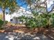 Exterior view of modern white home surrounded by lush tropical plants at 8472 Bay Breeze Ln, Sarasota, FL 34243