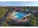 Aerial view of a community pool with lounge chairs, umbrellas and mature tropical landscaping at 12611 Elgin Ter, Lakewood Ranch, FL 34202