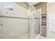 Modern tiled walk-in shower featuring glass door and built-in shelves for storage at 13908 Messina Loop, Bradenton, FL 34211