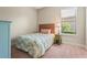 Sunny bedroom featuring plush carpeting, side table with lamp, and large window offering bright, natural light at 13908 Messina Loop, Bradenton, FL 34211