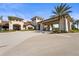 Grand entrance with palm trees, porte cochere, and elegant landscaping at 13908 Messina Loop, Bradenton, FL 34211