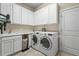 A well-organized laundry room with ample storage cabinets, a sink, and modern washer and dryer units at 13908 Messina Loop, Bradenton, FL 34211