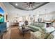 Open-concept living room with tray ceiling, ceiling fan, and seamless flow to kitchen and dining at 13908 Messina Loop, Bradenton, FL 34211