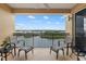 Balcony with lake view, black metal railings, and four cushioned chairs with tables at 147 Tampa E Ave # 702, Venice, FL 34285