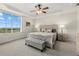 Comfortable bedroom with a ceiling fan, decorative tray ceiling, and a large window with a view at 147 Tampa E Ave # 702, Venice, FL 34285