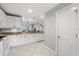 Bright kitchen with white appliances and cabinets, granite counters, and tile flooring at 147 Tampa E Ave # 702, Venice, FL 34285