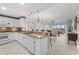 Open kitchen with white cabinets, granite countertops, and a view of the living area and balcony at 147 Tampa E Ave # 702, Venice, FL 34285