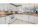 Bright kitchen features white cabinets, granite counters, and a breakfast bar overlooking living space at 147 Tampa E Ave # 702, Venice, FL 34285