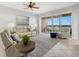 Bright living room features balcony access with views, comfortable seating, ceiling fan and stylish decor at 147 Tampa E Ave # 702, Venice, FL 34285