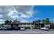 Beige condo building with palm trees and lots of parking spots available for residents and guests at 1515 Forrest Nelson Blvd # P107, Port Charlotte, FL 33952