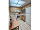 Well-lit kitchen with tiled floor featuring wood cabinets and essential white appliances at 1515 Forrest Nelson Blvd # P107, Port Charlotte, FL 33952