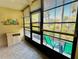 Enclosed lanai with tiled floor, window blinds and view of greenery at 1515 Forrest Nelson Blvd # P107, Port Charlotte, FL 33952