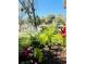 Tranquil landscaping featuring mature trees, lush greenery, and a sprinkler watering the foliage at 1515 Forrest Nelson Blvd # P107, Port Charlotte, FL 33952