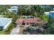Aerial view of a charming home with a terracotta roof, a pool, and lush greenery at 1555 Flower Dr, Sarasota, FL 34239