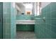 The bathroom boasts vintage blue tile, sink, shower, large mirror and unique features at 1555 Flower Dr, Sarasota, FL 34239