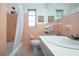 This bathroom features pink tile, a shower/tub and large mirror at 1555 Flower Dr, Sarasota, FL 34239