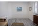 Bedroom featuring neutral walls, white trim, vintage furniture, and light gray flooring at 1555 Flower Dr, Sarasota, FL 34239