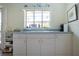 Kitchen view featuring white cabinets, countertops, a window, and decorations at 1555 Flower Dr, Sarasota, FL 34239