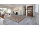 Bright living room with whitewashed fireplace, neutral tones and wood-look floors at 1555 Flower Dr, Sarasota, FL 34239