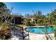 Inviting in-ground pool with decorative bench and lush landscaping, creating a private backyard oasis at 1555 Flower Dr, Sarasota, FL 34239