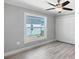 Bedroom features hardwood floors, closet with folding doors, ceiling fan and a view to the outside at 16491 Volkerts Ave, Port Charlotte, FL 33954