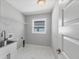 A clean laundry room with a sink, new cabinets, and marble style tiling at 16491 Volkerts Ave, Port Charlotte, FL 33954