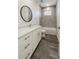 Modern bathroom featuring a shower-tub, white vanity, round mirror, and stylish fixtures at 18290 Grace Ave, Port Charlotte, FL 33948