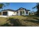 Charming single-story home featuring a modern design, well-kept lawn, and neatly trimmed landscaping at 18290 Grace Ave, Port Charlotte, FL 33948