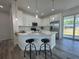 Modern kitchen features white cabinetry, stainless steel appliances, and island with bar seating and pendant lights at 18290 Grace Ave, Port Charlotte, FL 33948