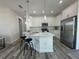 Modern kitchen features white cabinetry, stainless steel appliances, and island with bar seating and pendant lights at 18290 Grace Ave, Port Charlotte, FL 33948