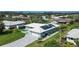 Aerial view of a single-story home featuring a paved driveway, well-maintained lawn and solar panels on the roof at 217 Giotto Dr, Nokomis, FL 34275