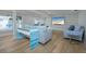 Bright living room featuring light wood floors, coastal-themed decor, and a large flat-screen television at 231 Hourglass Way # V5, Sarasota, FL 34242