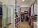 Spacious walk-in closet with built-in shelving for shoes, clothes, and accessories, plus a large three paneled mirror at 231 Hourglass Way # V5, Sarasota, FL 34242