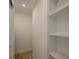 Bright walk-in closet with white walls, shelving, and light wood-look flooring for efficient storage at 231 Hourglass Way # V5, Sarasota, FL 34242