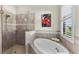 Elegant bathroom featuring a soaking tub, a separate glass shower, and a window with shutters at 23547 Waverly Cir, Venice, FL 34293