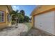 Backyard featuring a paver walkway, tropical landscaping, and access to the detached garage at 2416 Webber St, Sarasota, FL 34239